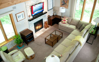 Bluffside's living room area with couch, chair, fireplace and TV