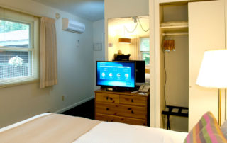 Woodview room interior with large bed, TV and window 