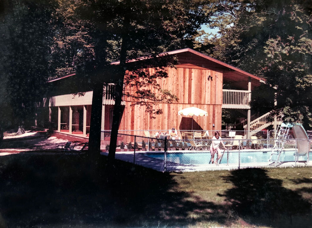 Exterior of Shallows motel and pool with guests from 1960s