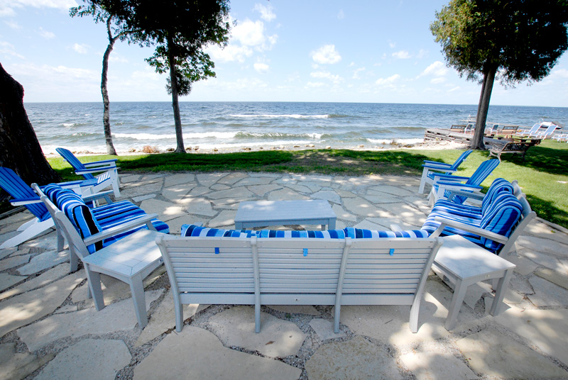 Deck chairs on stone patio overlooking the bay