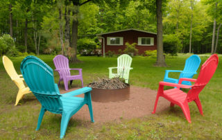 Colorful lawn chairs surrounding fire pit near Falun House 