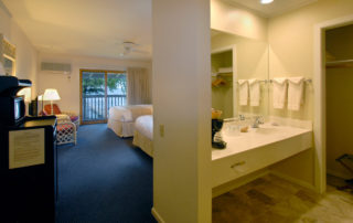  Interior of a Shoreside Motel room with bathroom, two beds, and chairs