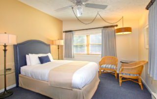 Woodview room interior with large bed, chairs and windows 