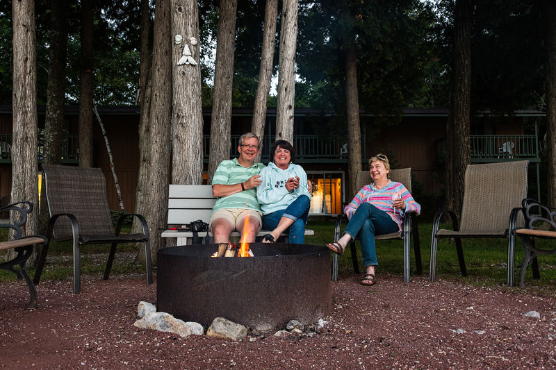 Three guests enjoying the firepit