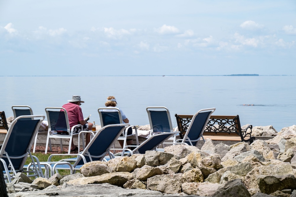 A couple sitting by the water at Shallows Resort.
