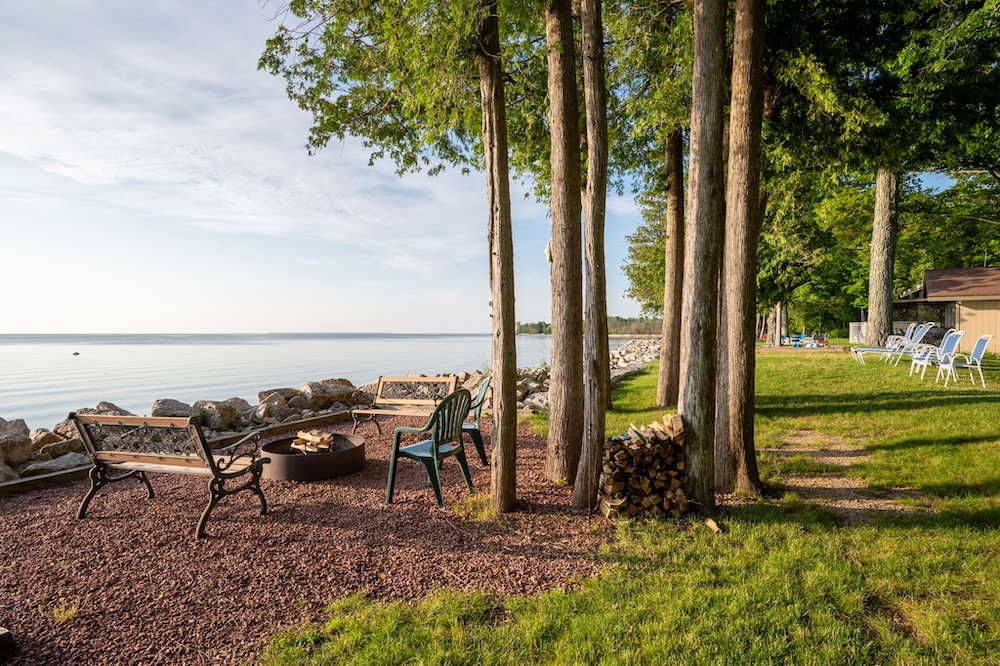 Waterfront fire pit with seating and lake view in background
