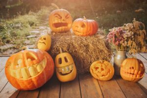 A set of pumpkins with ghost faces carved into them