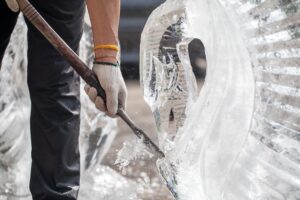 A man carving a figure out of an ice block